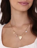 Collar corto doble con cadena dorada, con dijes de corazón, moño y piezas perladas.