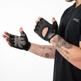 Guantes de entrenamiento sin dedos, color negro y rosa. La parte superior es de malla transpirable rosa con bordes grises reflectantes. La palma es negra con un patrón de agarre hexagonal gris. Cuentan con una tira de velcro en la muñeca con la inscripción "GAINS.".