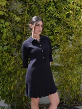 Vestido camisero verde seco de corte holgado, con cuello camisero, mangas 3/4 y cierre frontal con botones.