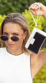 Billetera mediana marca Lincoln's confeccionada en cuero sintético con diseño bicolor. Presenta una tapa en tono dorado metalizado con cierre de presilla y cuerpo negro con compartimento de cremallera. Cuenta con múltiples divisiones internas para tarjetas, billetes y monedas, además de una práctica correa de mano.