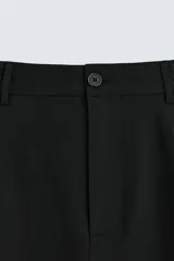Pantalón de vestir color beige, corte wide fit, con cintura elástica, pliegues frontales, bolsillos laterales y traseros de vivo.