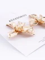 Par de aros colgantes dorados con forma de flor de cuatro pétalos.