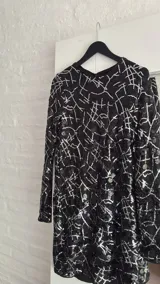 Minivestido negro con lentejuelas y estampado geométrico blanco.