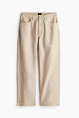 Pantalón de lona color beige, de corte holgado con pierna ancha y cinco bolsillos.