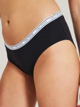 Bombacha hipster negra de algodón y elastano, con cintura elástica blanca con logo Tommy Hilfiger repetido.