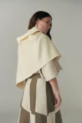 Chal unisex de lana fina sin teñir, realizado con retazos de telas diseñadas por Don Baez. Presenta una grifa de cuero aplicada.