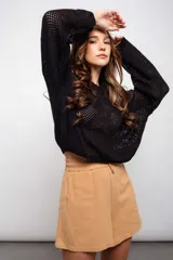 Buzo negro de acrílico con tejido calado y mangas largas.