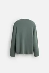 Sweater azul de punto con textura, corte holgado, cuello redondo y mangas largas con puños acanalados.