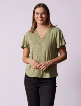 Remera verde con tejido melange, escote en V y aplique de crochet en la parte delantera.