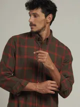 Camisa de cuadros en tonos azules y verdes, con cuello clásico y cierre frontal de botones.