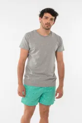 Short de baño azul con estampado de hojas de palmera en tonos azules, blancos y rosados.