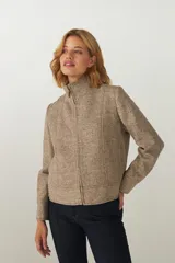 Campera marrón con cuello alto y cierre frontal, con detalle de pespuntes en puños, ruedo y cuello.