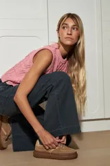 Chaleco marrón de punto con diseño trenzado, cuello redondo y sisas con volantes celestes.