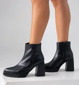 Bota de cuero negro con taco cuadrado y cierre lateral.