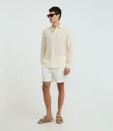 Camisa celeste de lino con cuello camisero, abotonadura frontal y mangas largas.