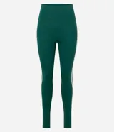 Legging deportiva ajustada al cuerpo, color verde oscuro, con una franja lateral blanca que recorre la pierna. Posee cintura alta y tiro medio.
