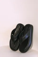Sandalias negras de cuero sintético con plataforma y diseño minimalista.