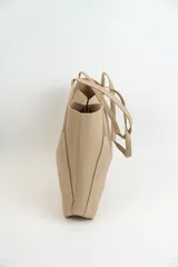 Bolso tipo tote de cuero sintético color negro, con textura granulada y doble asa de hombro.