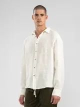 Camisa celeste de lino, de manga larga con botones de coco y parche de la marca.