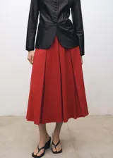 Falda midi color rojo con tablas y forro interior.