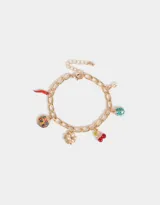 Pulsera dorada con eslabones gruesos y charms colgantes: pimiento rojo, moneda con la inscripción 'Good Luck', trébol de cuatro hojas, cerezas rojas y mariquita turquesa.