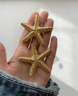 Pendientes en forma de estrellas de mar, de gran tamaño y terminación dorada.