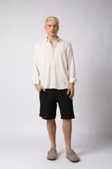 Camisa de manga larga color beige claro, con cuello abierto y calce relajado.