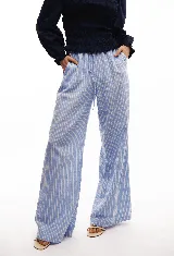 Pantalón pijamero de lino a rayas verticales celestes y blancas, con corte ancho y ajuste de cordón en la cintura.