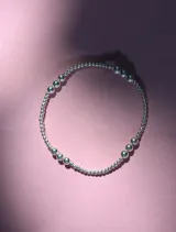 Pulsera elástica de plata 925 con cuentas redondas de diferentes tamaños.