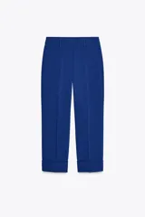Pantalón de vestir azul eléctrico, de tiro alto, con bolsillos delanteros y falsos bolsillos de vivo en la espalda. Pierna recta con vuelta en el bajo.