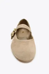 Bailarinas color beige de gamuza con tira sobre el empeine y hebilla dorada.