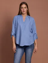 Blusa celeste con escote en V y mangas 3/4 regulables con presilla y botón.