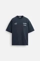 Sudadera azul marino de corte holgado, confeccionada en tejido de algodón con interior de rizo. Tiene cuello redondo, manga corta y estampados gráficos y textos en blanco en la parte delantera y trasera.