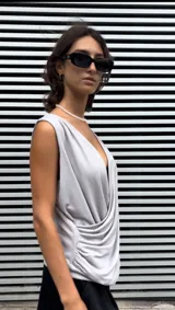 Blusa gris sin mangas, con escote en V drapeado y frunces laterales.