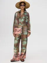 Pantalón de tiro alto con estampado abstracto en tonos marrones, verdes y rosados.