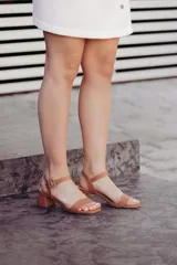 Sandalias de cuero color marrón claro, con tira delantera y tobillera con hebilla. Taco cuadrado bajo.