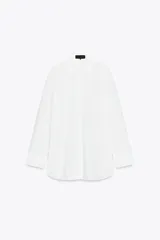 Camisa blanca de corte amplio, con cuello solapa, manga larga y cierre frontal con botones.