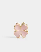 Broche de metal dorado con forma de trébol de cuatro hojas color rosa.