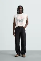 Musculosa blanca con efecto lavado, cuello redondo y sisa ancha. Estampado frontal con la leyenda "L.A. Legend Trailblazer" y un águila.