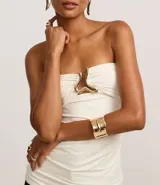 Blusa sin breteles color blanco, confeccionada en microfibra, con escote corazón con cutout, aviamento metalizado y fruncidos.