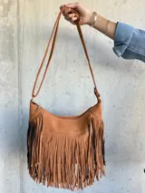 Cartera tipo bandolera color camel con flecos en la parte frontal.