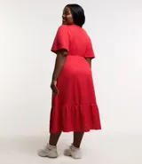 Vestido midi rojo de malla texturizada, con escote en pico, mangas cortas, aro central en el escote y recorte cutout lateral en la cintura.