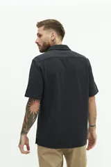 Camisa de manga corta color beige, con textura tipo crepé y cuello camisero.