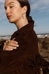 Chaqueta marrón de gamuza con flecos en la parte delantera y trasera.