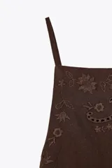 Top marrón con tirantes finos ajustables, escote recto, espalda descubierta con tiras ajustables y bordados florales.
