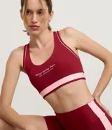 Top deportivo femenino color bordó, modelo copa nadador, con ribetes y banda inferior en rosa claro. Presenta un estampado frontal en blanco con el texto "Vintage Sporting League - The Weekend Club".