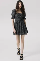 Vestido corto de crepé de algodón con estampado floral en blanco y negro, escote cuadrado con volantes, mangas cortas abullonadas con elástico en los puños, cuerpo ajustado con elástico y falda con vuelo.