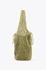 Bolso shopper de hombro color verde oliva, trenzado con cordones gruesos. Tiene doble asa ancha para el hombro y un bolso interior de tela con cierre fruncido.