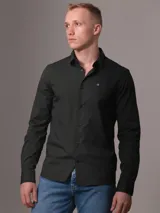 Camisa de vestir verde oscuro de popelín de algodón elástico, corte slim, con cierre frontal de botones y logo CK bordado en el pecho.