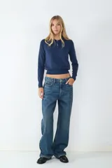 Jean de tiro alto color azul denim, corte loose con pernera ancha. Diseño clásico de cinco bolsillos con cierre de cremallera y botón metálico.